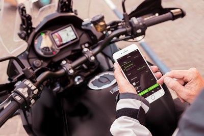 Rider using RIDEOLOGY THE APP on phone on their Kawasaki motorcycle