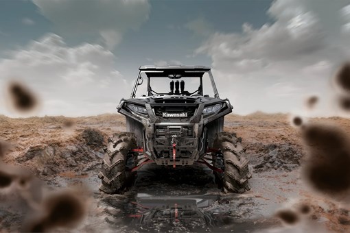 Front angle of a person driving a side x side through mud. opens in a new window