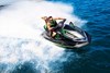 Three-quarter front angle of people riding a personal watercraft on water.