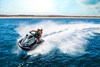 Front angle of people riding a personal watercraft on water.