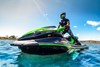 Profile angle of person riding a personal watercraft on water.