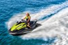 Three-quarter front angle of a person riding a personal watercraft on water.