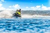 Front angle of person riding a personal watercraft on water.