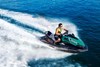 Three-quarter front angle of person riding a personal watercraft on water.
