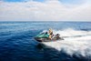 Profile angle of person riding a personal watercraft over water.