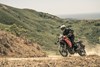 Three-quarter front angle of person riding a motorcycle off-road.