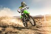 Three-quarter front angle of a person riding a motorcycle off-road.