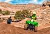 Front angle of a person riding an ATV on a track.