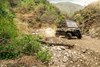 Front three-quarter angle of a person driving a side x side off-road.