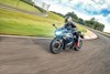 Front three-quarter angle of a person riding a motorcycle on a racetrack.