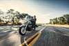 Three-quarter front angle of people riding a motorcycle on a highway.