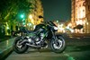 Profile angle of a motorcycle staged in front of a city background.