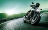 Three-quarter front angle of person riding a motorcycle on a highway.