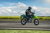 Profile angle of person riding a motorcycle on a highway.