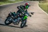 Front three-quarter angle of person riding a motorcycle on a racetrack.