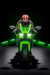 Front angle of person riding a motorcycle shown in a black studio background.