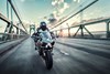Front angle of person riding a motorcycle over a bridge