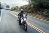 Profile angle of person riding a motorcycle on a paved road.
