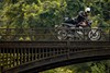 Profile angle of person with a motorcycle on a bridge.