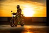 Front angle of a person sitting on a motorcycle at at sunrise. 