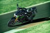 Front angle of a person riding a motorcycle on a track going into a corner.