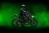 Profile angle of a person on a motorcycle with a green studio background. 