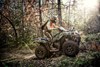 Side angle of a person riding an ATV off-road.