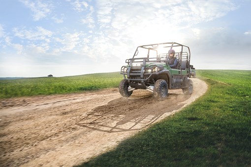 Front three-quarter angle of a person driving a side x side off-road. opens in a new window