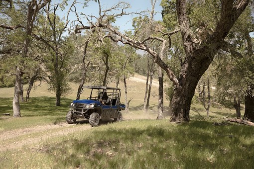 Front three-quarter angle of a person driving a side x side off-road. opens in a new window