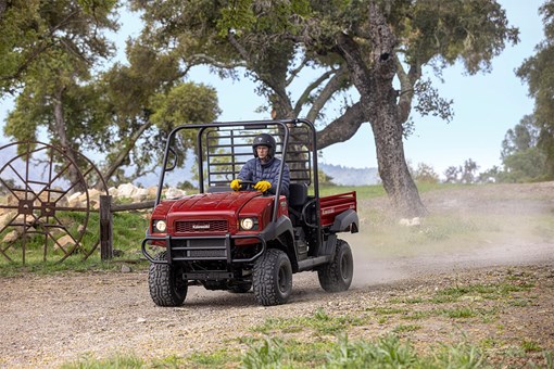 Three-quarter front angle of a person driving a side x side off-road. opens in a new window