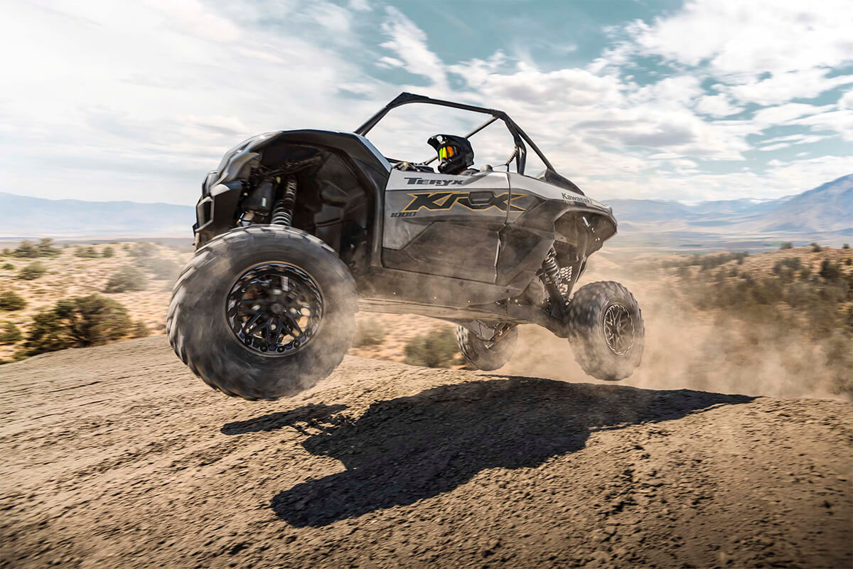 Side angle of a person getting air on a side x side off-road.