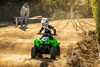 Front angle of a child riding over the whoops on a youth ATV off-road.