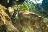 Three-quarter front angle of a person riding a motorcycle off-road.