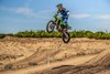 Three-quarter front angle of a person getting air on a motorcycle off-road.