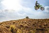 Side angle of a person getting air on a motorcycle off-road.