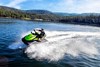 Three-quarter front angle of a person on a personal watercraft on the water. 