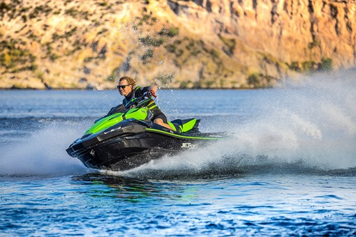 Three-quarter front angle of a person turning on a personal watercraft on the water. opens in a new window
