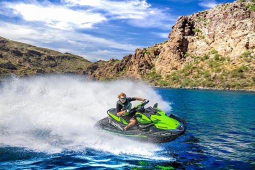 Side angle of a person on a personal watercraft on the water. opens in a new window