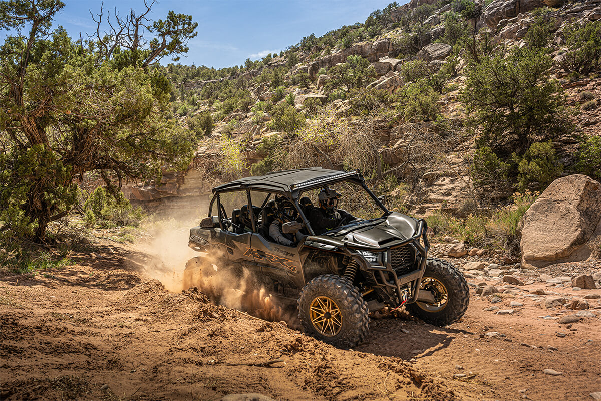 Three-quarter front angle of a person driving a side x side in a canyon off-road.