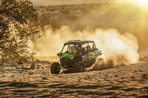 Three-quarter front angle of a person making a turn in a side x side off-road. opens in a new window