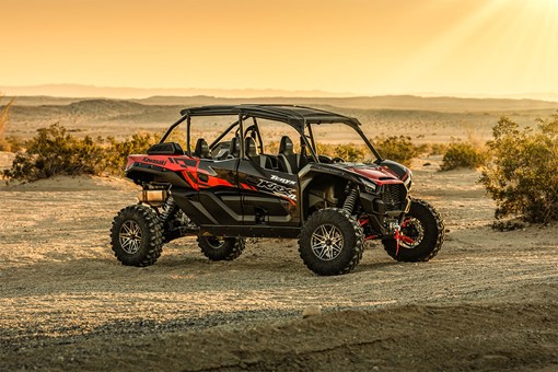 Three-quarter front angle of a red side x side staged off-road. opens in a new window