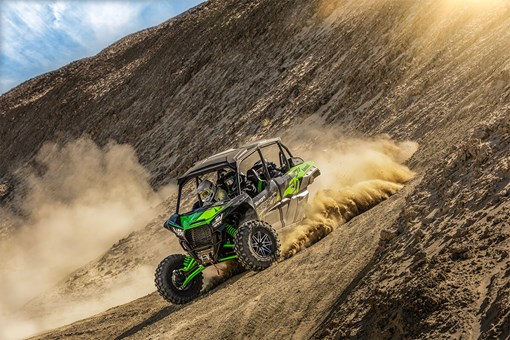 Three-quarter front angle of a person driving a side x side off-road. opens in a new window