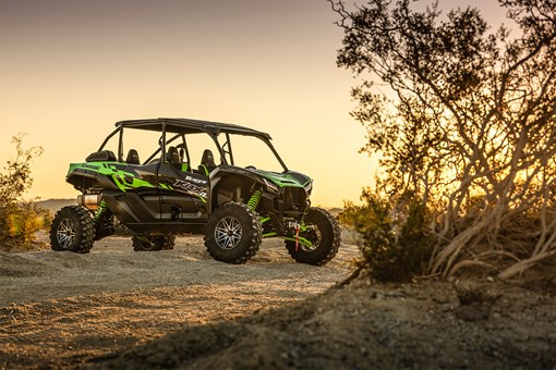 Three-quarter front angle of a green side x side staged off-road. opens in a new window