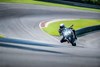 Front angle of a person riding a motorcycle on a racetrack.