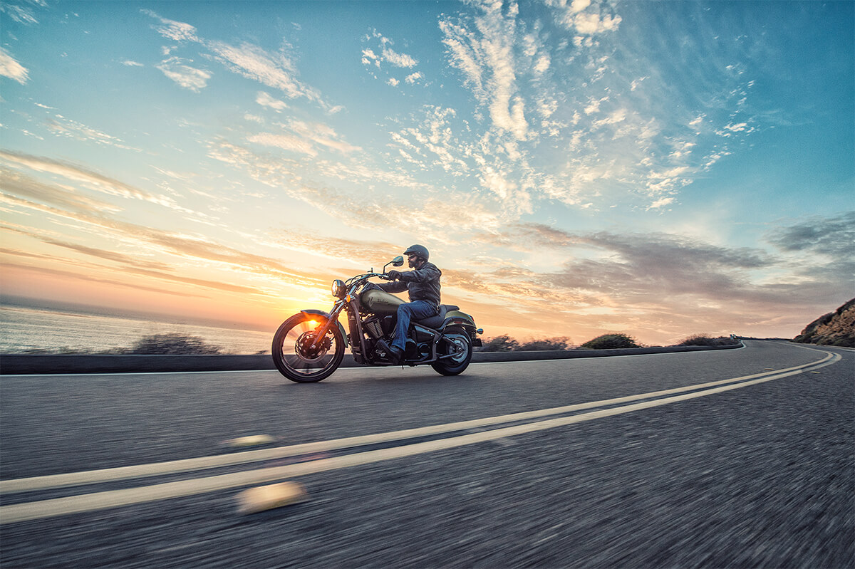 Side angle of a person riding a motorcycle on a highway.