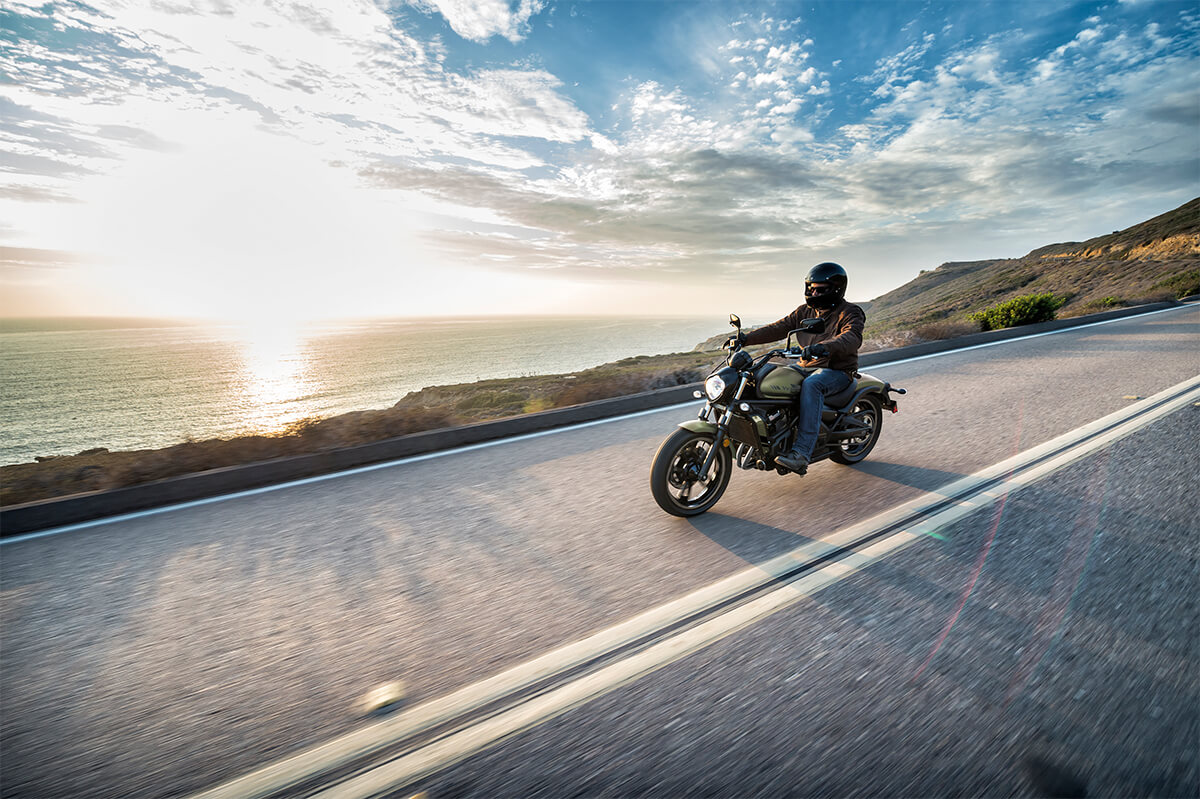Side angle of a person riding a motorcycle on a highway.