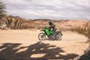 Side angle of a person riding a motorcycle off-road.