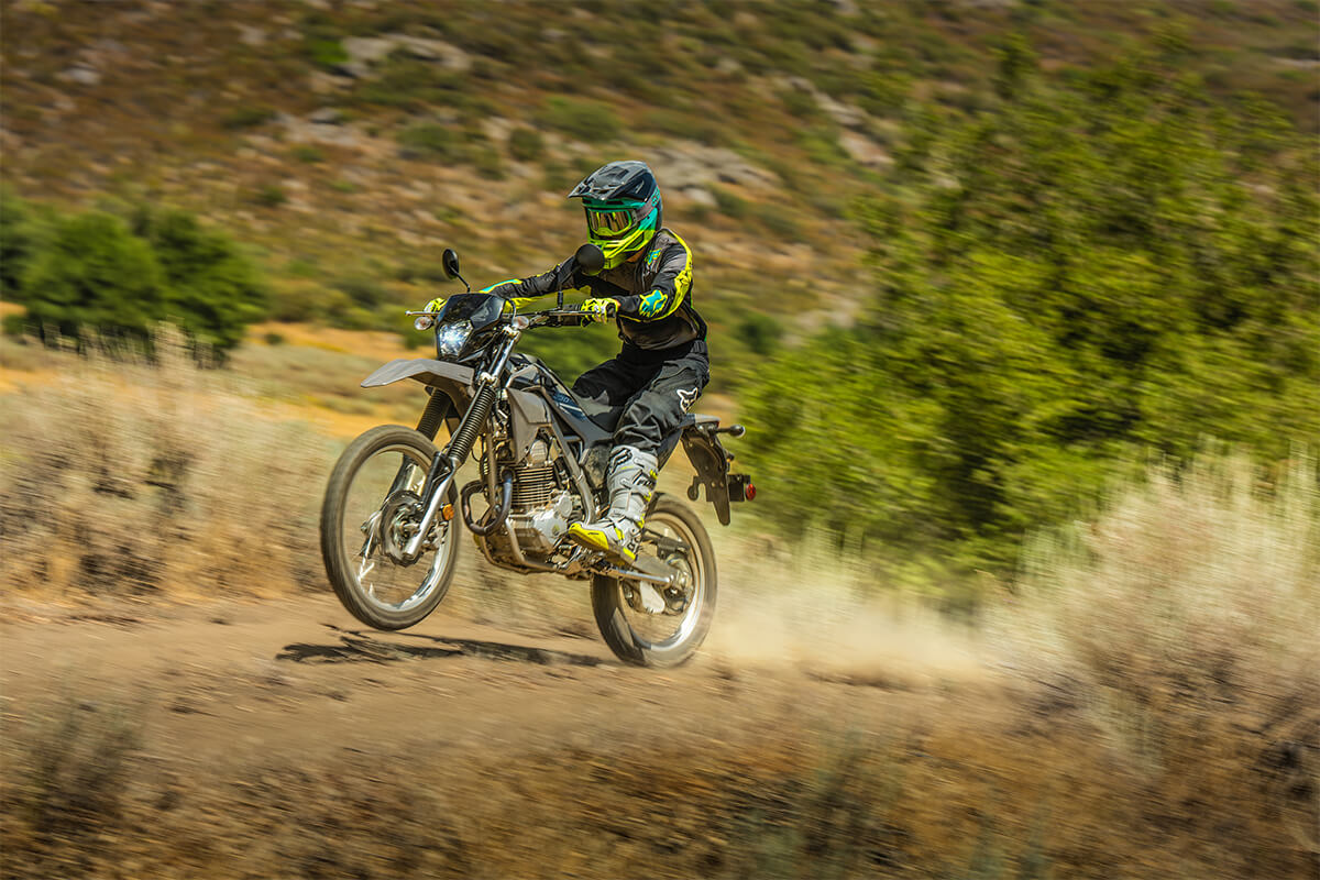Three-quarter front angle of a person riding a motorcycle off-road.