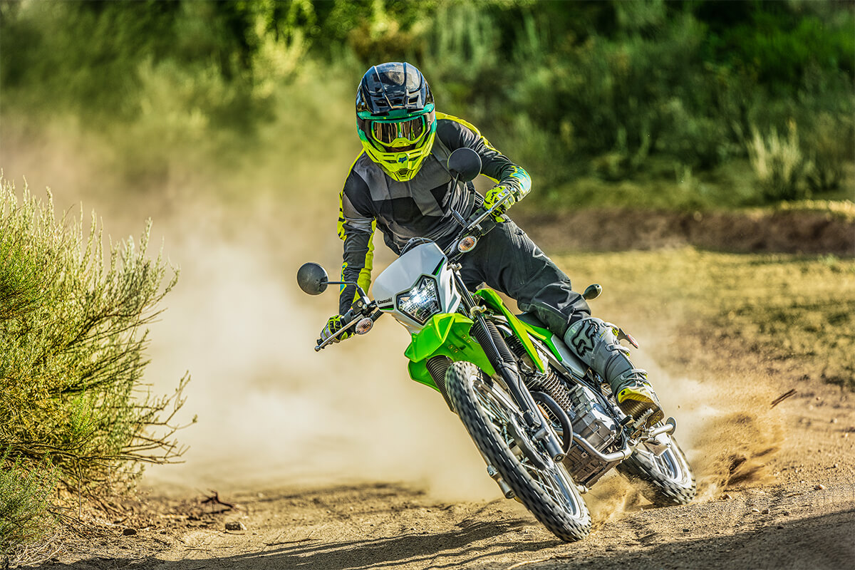 Three-quarter front angle of a person making a sharp turn on a motorcycle off-road.