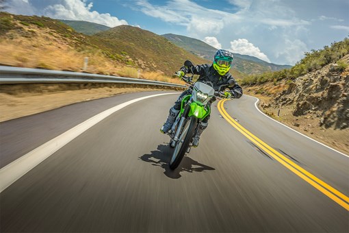 Front angle of a person riding a motorcycle on a highway. opens in a new window
